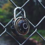 black and gray code padlock anchored on chain-link fence selective focus photo