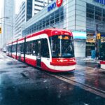 white and red bus on road near buildings during daytime